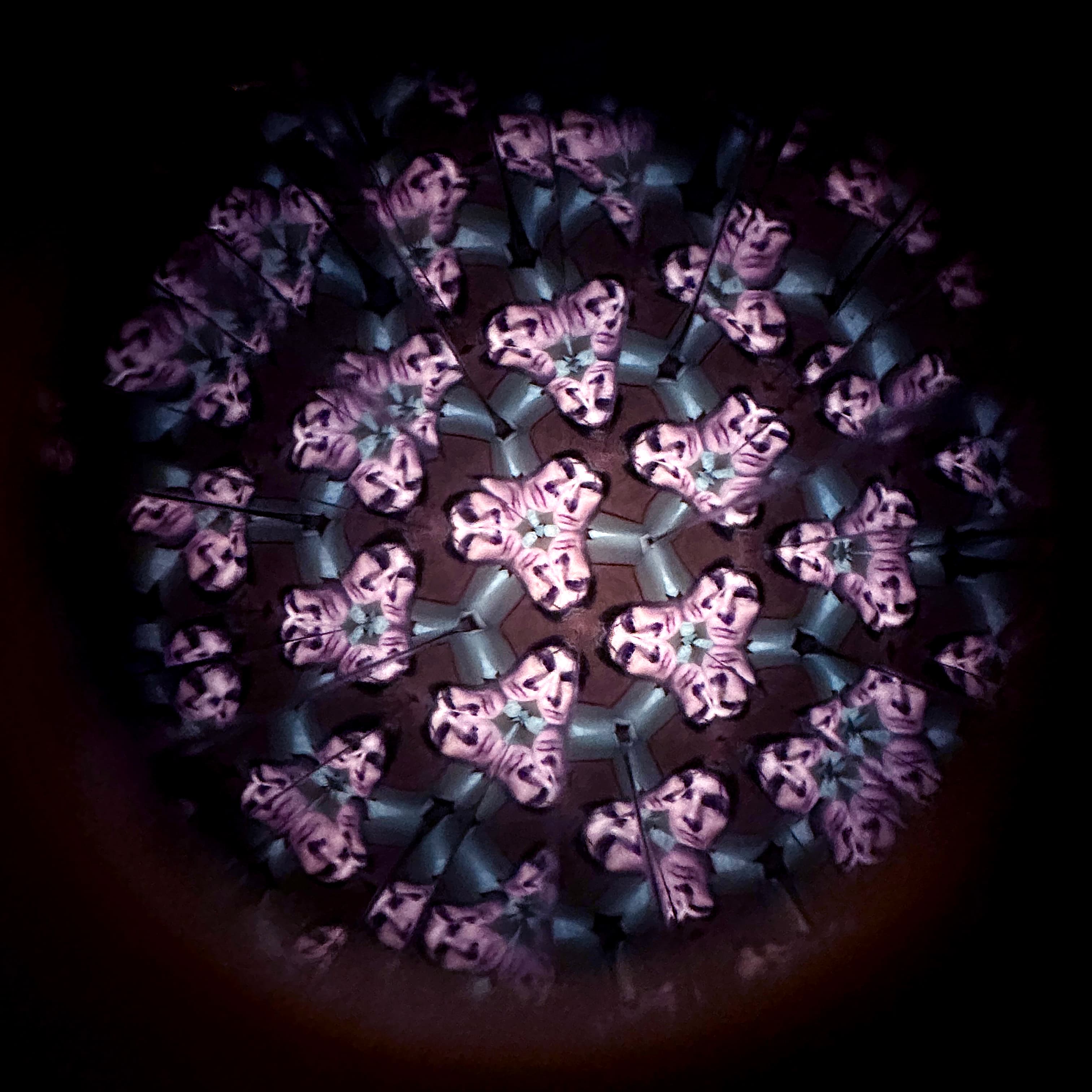 A kaleidoscope effect showing multiple mirrored images of a person in pink and purple tones.