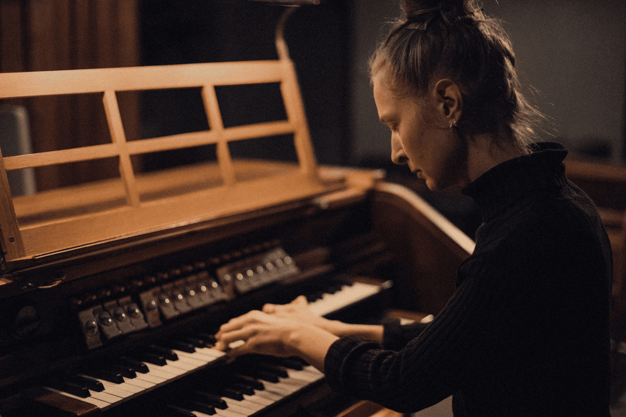 A person is playing an organ with focused attention.